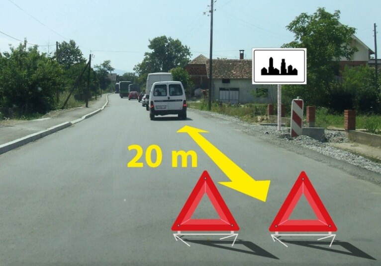 У ситуацији приказаној на слици колона заустављених моторних возила на путу у насељу: