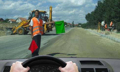 У ситуацији приказаној на слици радник извођача радова даје знак заставицом који означава: